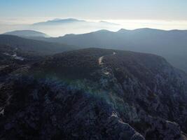 nebuloso montanha picos com floresta, azul céu com a Sol às Está zênite. natureza fotografia a partir de uma pássaro olho Visão com cópia de espaço. panorâmico Visão do lindo ásia montanha panorama foto