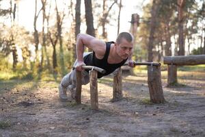 bonito caucasiano homem empurrar acima ao ar livre exercite-se Cruz Treinamento manhã bombeamento tríceps braço exercício Esportes terra foto