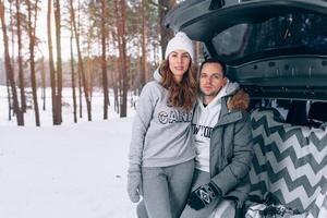 lindo família casal dentro uma Nevado inverno floresta sentado dentro a tronco do seu carro foto