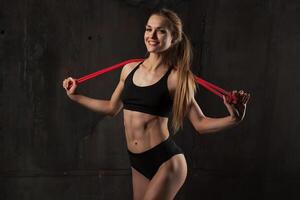 esporte, atividade. fofa mulher com saltando corda. muscular menina bl foto