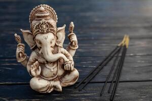 hindu Deus ganesh em Preto fundo. estátua em de madeira mesa foto