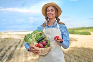 mulher agricultor Palha chapéu avental em pé terras agrícolas sorridente fêmea agrônomo especialista agricultura agronegócio feliz positivo caucasiano trabalhador agrícola campo foto