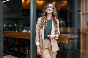 o negócio mulher restaurante proprietário vestido elegante terninho em pé perto restaurante grande janela foto