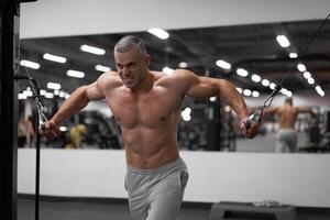 muscular Atlético fisiculturista em pé Treinamento peito e ombros músculos em ginástica equipamento foto