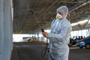 trabalhador vestindo protetora terno desinfecção engrenagem desinfectar superfície público Lugar, colocar foto