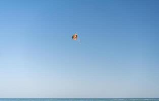 mosca com colorida pára-quedas às a de praia. foto