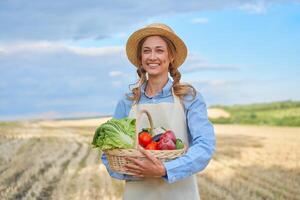 mulher agricultor Palha chapéu avental em pé terras agrícolas sorridente fêmea agrônomo especialista agricultura agronegócio feliz positivo caucasiano trabalhador agrícola campo foto