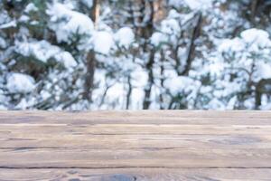 lindo inverno cena. borrado fundo do Nevado Natal natureza fundo, madeira mesa topo em brilhante bokeh. para produtos exibição Natal Tempo zombar acima foto