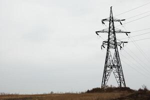 Alto Voltagem poder torre e elétrico linhas contra céu. foto