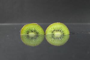 dois ou três círculos do verde kiwi semicírculo com uma Preto lustroso ainda vida foto