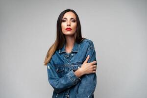 lindo caucasiano menina dentro uma jeans Jaqueta posando dentro a estúdio em uma branco fundo. foto