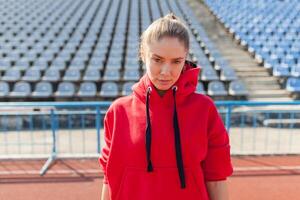 jovem Esportes mulher dentro suéter em repouso depois de corrida Treinamento em a corrida rastrear às verão foto