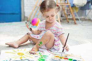 retrato do pequeno Loiras menina pintura, verão ar livre. foto