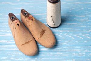 couro amostras para sapatos e de madeira sapato último em azul de madeira mesa. foto