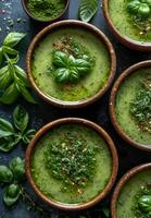 ai gerado taças do verde sopa com fresco manjericão e vermelho Pimenta flocos em Sombrio fundo foto