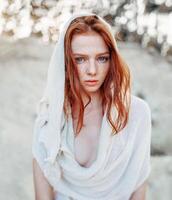 fechar acima retrato do uma lindo vermelho cabelos menina dentro branco medieval vestir em brilhando Sol. fada conto história sobre bravo coração mulher. foto