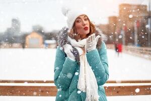 lindo adorável meia idade menina com encaracolado cabelo caloroso inverno jaquetas carrinhos gelo rinque fundo Cidade quadrado. foto