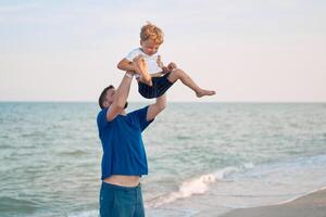 pai filho gastos Tempo juntos mar período de férias jovem Papai criança pequeno Garoto caminhando de praia foto