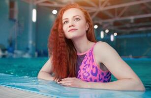 lindo jovem mulher dentro a interior natação piscina. Atlético sexy garota. saudável estilo de vida foto