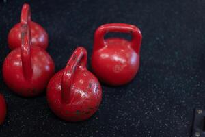 vermelho velho kettlebell em pé Preto chão com cópia de espaço foto