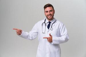 jovem bonito moderno médico dentro uma branco médico vestido carrinhos dentro a estúdio em uma branco fundo. aluna estagiário do uma médico universidade. foto