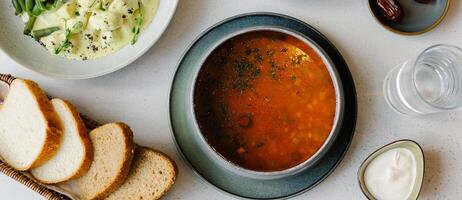 Ramadã Comida preparação para iftar refeição durante a piedosos mês. vidro do água e tigela do datas. sopa, Curry caipira e beterraba salada foto