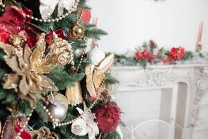 fechar acima do decoração vermelho e ouro decorado em verde Natal árvore ou pinho com desfocado borrado bacground foto