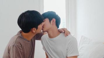 casal gay asiático beijando na cama em casa. jovens asiáticos lgbtq homens felizes relaxam descansam juntos, passam um tempo romântico depois de acordar no quarto em casa no conceito de manhã. foto