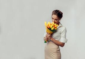 lindo elegante jovem bussines mulher em pé em a estúdio com cinzento fundo foto