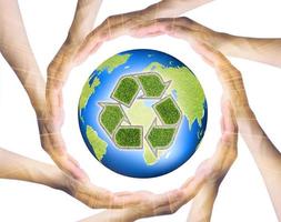 mãos fazendo um círculo ao redor da terra reciclada foto