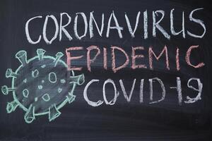 surto aviso. escrito branco giz em quadro-negro dentro conexão com epidemia do coronavírus mundialmente. foto