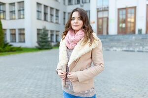 lindo europeu menina vestido caloroso outono roupas anda em ruas com escritório edifícios fundo. foto