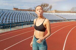 lindo caucasiano menina atleta em repouso depois de corrida em uma corrida acompanhar. foto