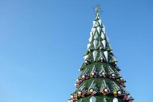 cidade Natal árvore contra uma azul céu. Natal guirlandas. finais de semana e feriados foto