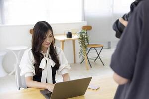 uma trabalhando japonês mulher com fotógrafo dentro a casa escritório fechar-se foto