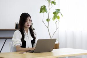 uma trabalhando japonês mulher de controlo remoto trabalhos dentro a casa escritório fechar-se foto