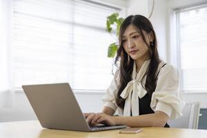 uma trabalhando japonês mulher de controlo remoto trabalhos dentro a casa escritório fechar-se foto