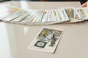 tver, Rússia - fevereiro 11, 2023. tarot cartões, tarot cartão adivinhação, esotérico fundo. uma mulher faz uma disposição em a cartões às a mesa. adivinhação, previsões em tarot cartões. foto