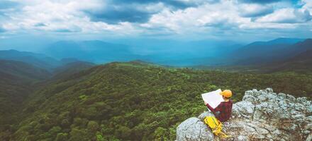 mulher asiática viaja relaxar no feriado. ver mapa explorar as montanhas foto