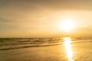 desfoque abstrato bela praia do mar com hora do pôr do sol para segundo plano foto