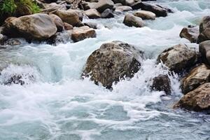 ai gerado tormentoso rio com Forte atual, lavando ampla pedras foto