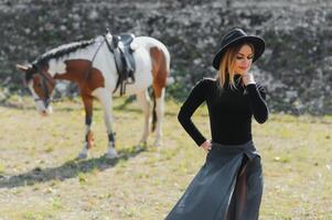 elegante retrato do uma lindo jovem mulher e cavalo foto