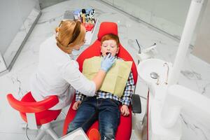 pequeno Garoto tendo dele dentes examinado de uma dentista foto