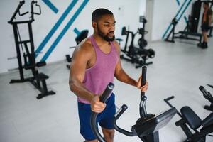 peso Treinamento africano fazendo musculação dentro academia. foto