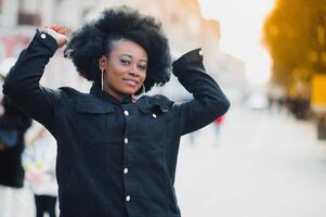 ao ar livre fechar acima retrato do jovem fofa feliz sorridente africano americano mulher com afro Penteado. foto