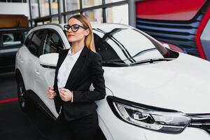 o negócio mulher compra uma carro às uma carro concessionária. conceito do feliz o negócio pessoas foto