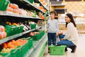 mãe e criança compras às agricultores mercado para frutas e legumes foto