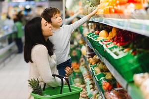 mãe e criança compras às agricultores mercado para frutas e legumes foto