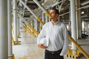 feliz masculino industrial técnico dentro uma fábrica foto