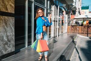 oferta, consumismo, dinheiro e pessoas conceito - feliz jovem mulher com compras bolsas e crédito cartão dentro Shopping foto